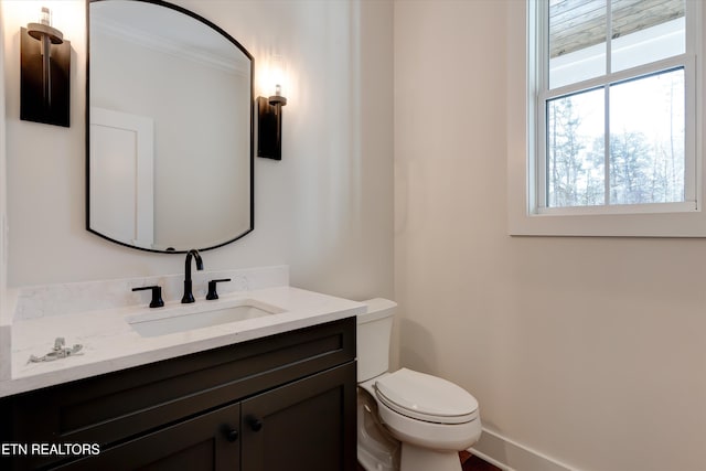 bathroom with vanity, ornamental molding, and toilet