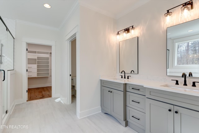 bathroom with vanity, crown molding, and a shower with door