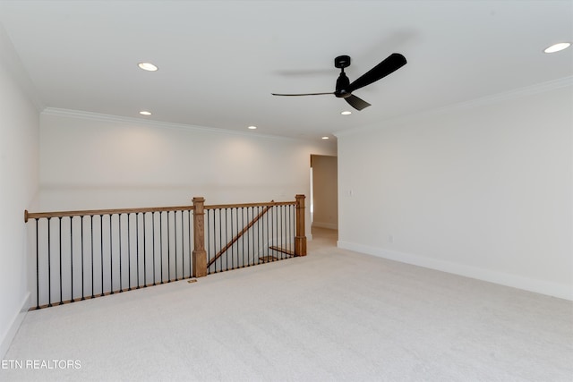 carpeted spare room with ceiling fan and ornamental molding