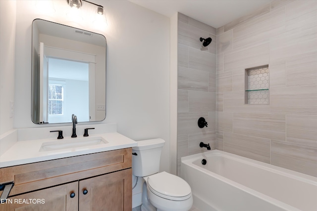 full bathroom featuring tiled shower / bath combo, vanity, and toilet