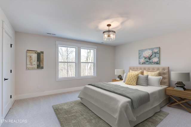 carpeted bedroom featuring a chandelier