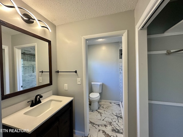 bathroom featuring vanity, toilet, and a textured ceiling