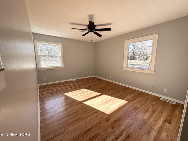 unfurnished room featuring ceiling fan, a healthy amount of sunlight, and hardwood / wood-style floors