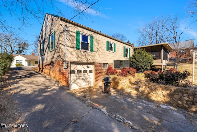 view of front facade featuring a garage and a sunroom