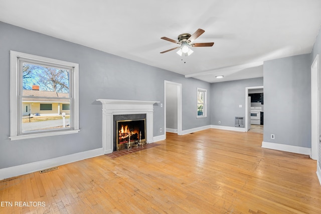 unfurnished living room featuring ceiling fan and light wood-type flooring