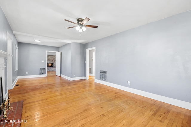 unfurnished living room featuring ceiling fan, light hardwood / wood-style floors, and heating unit