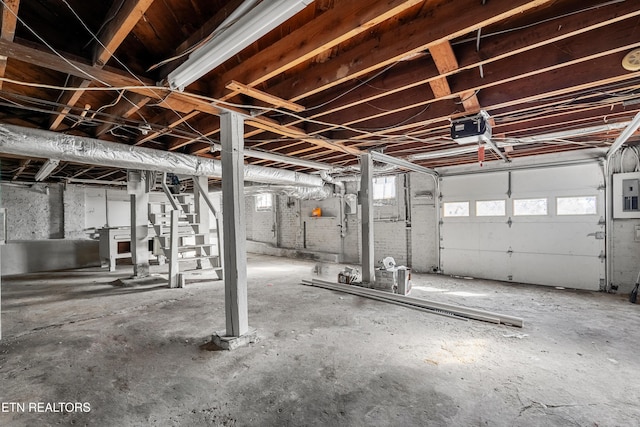 garage with a garage door opener and electric panel