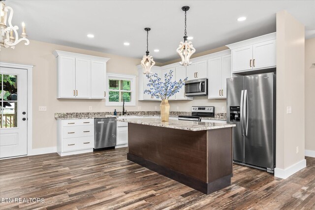 1918 Willow Grove Hwy, Monroe, TN 38573 - kitchen with appliances with stainless steel finishes, a chandelier, dark wood-style floors, white cabinetry, and a kitchen island