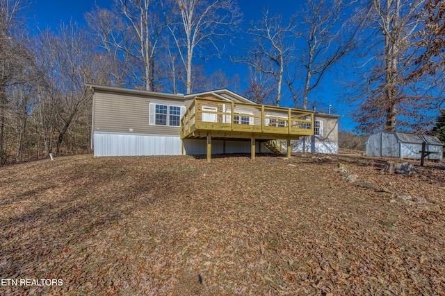 back of property featuring a wooden deck and a storage shed