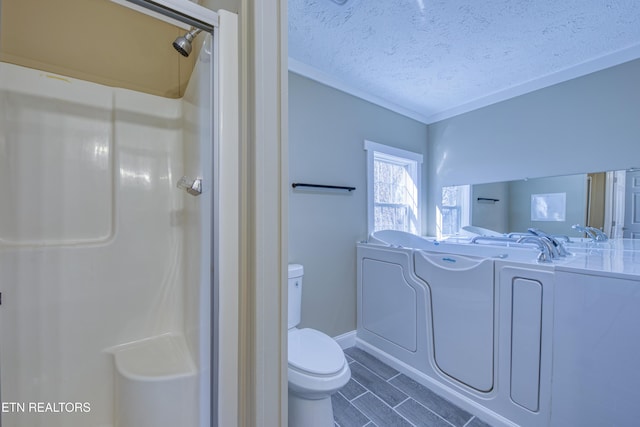 bathroom featuring toilet, a textured ceiling, independent washer and dryer, and a bathing tub