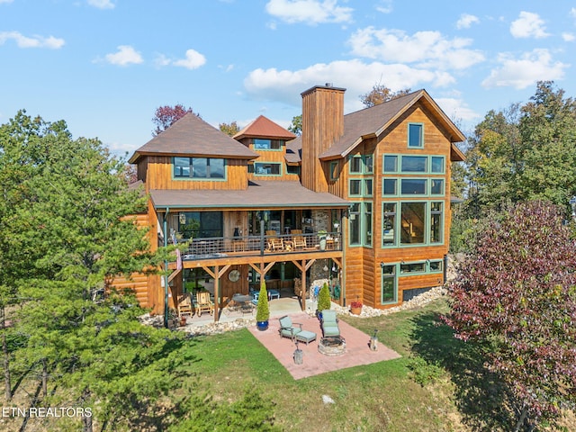 back of house with a patio and a lawn