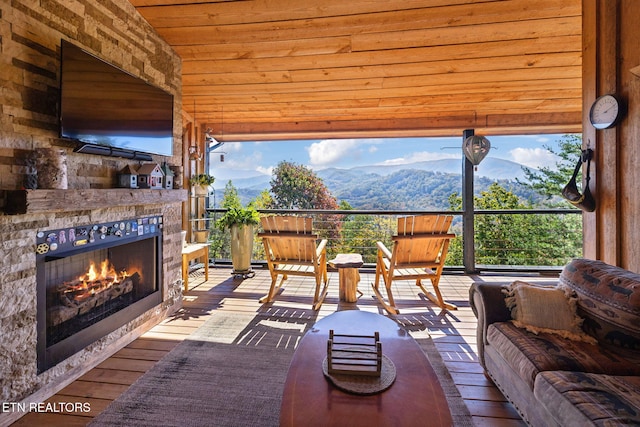 interior space featuring a mountain view and an outdoor stone fireplace