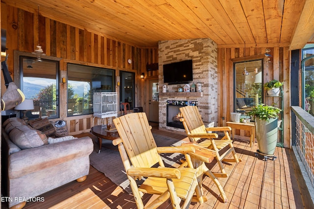 sunroom featuring wood ceiling, a fireplace, and vaulted ceiling