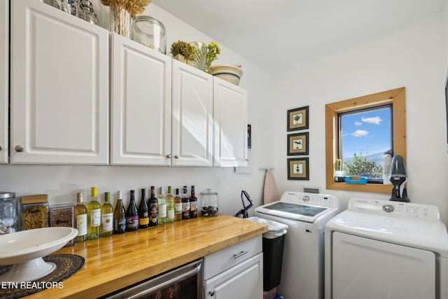 laundry room featuring washer and clothes dryer, cabinets, and bar area