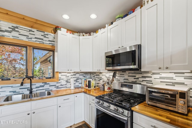 kitchen featuring white cabinetry, sink, and appliances with stainless steel finishes