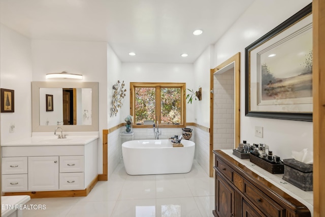 bathroom featuring tile walls, vanity, tile patterned floors, and a tub