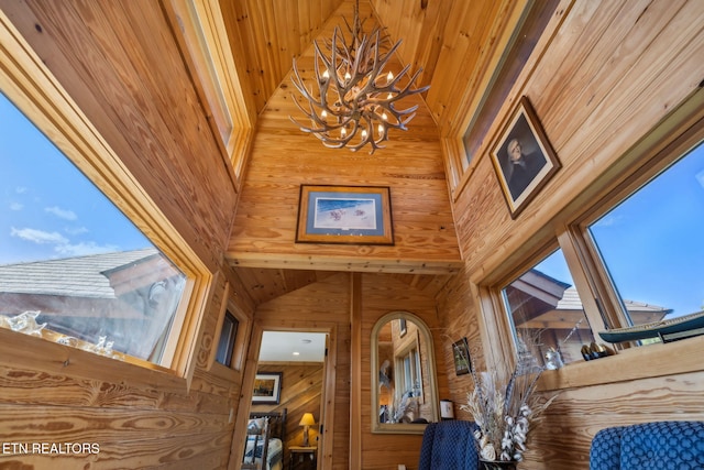 details with a notable chandelier and wood walls