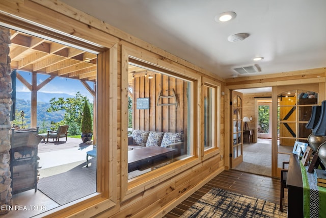 entryway featuring dark wood-type flooring and wood walls