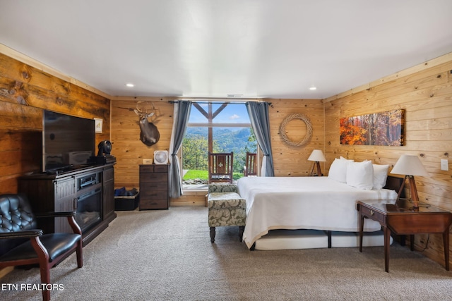 carpeted bedroom featuring wooden walls