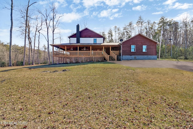 back of house featuring covered porch and a lawn