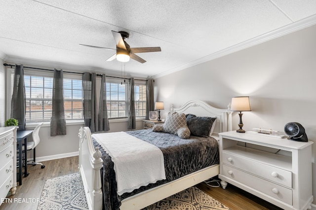 bedroom featuring hardwood / wood-style flooring, ornamental molding, ceiling fan, and a textured ceiling