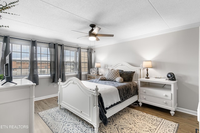 bedroom with crown molding, wood-type flooring, and a textured ceiling