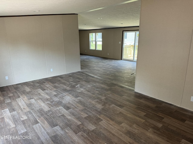 unfurnished room with dark hardwood / wood-style flooring and a textured ceiling