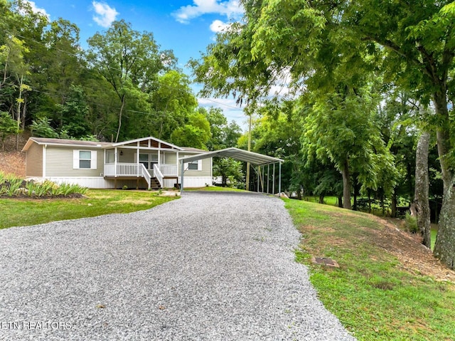 manufactured / mobile home with a carport, a porch, and a front yard