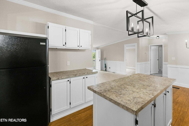 kitchen with crown molding, black fridge, pendant lighting, and white cabinets