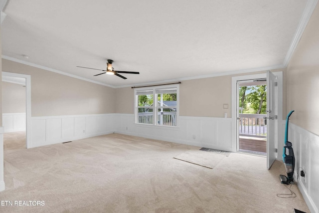 unfurnished room featuring crown molding, light colored carpet, and ceiling fan