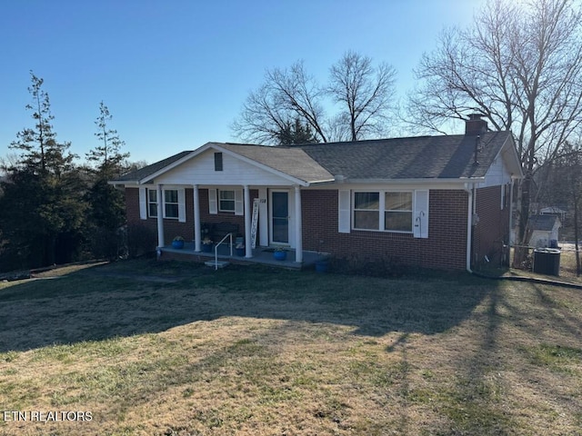 ranch-style house featuring cooling unit, covered porch, and a front lawn