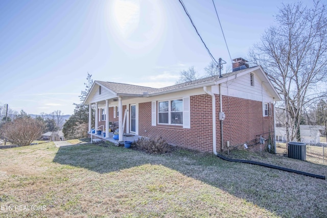 view of front of house with cooling unit and a front lawn