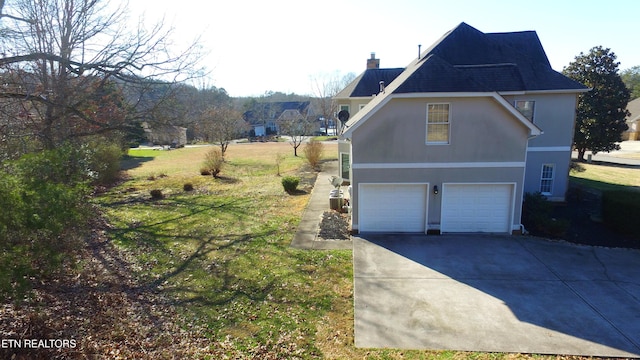 view of home's exterior with a garage and a yard