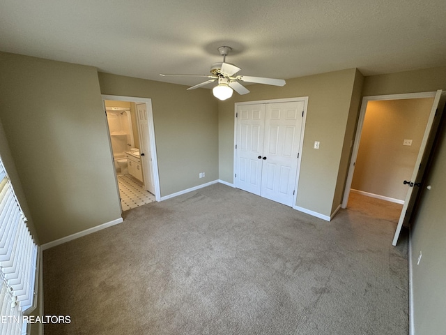 unfurnished bedroom featuring light colored carpet, a closet, ceiling fan, and ensuite bathroom