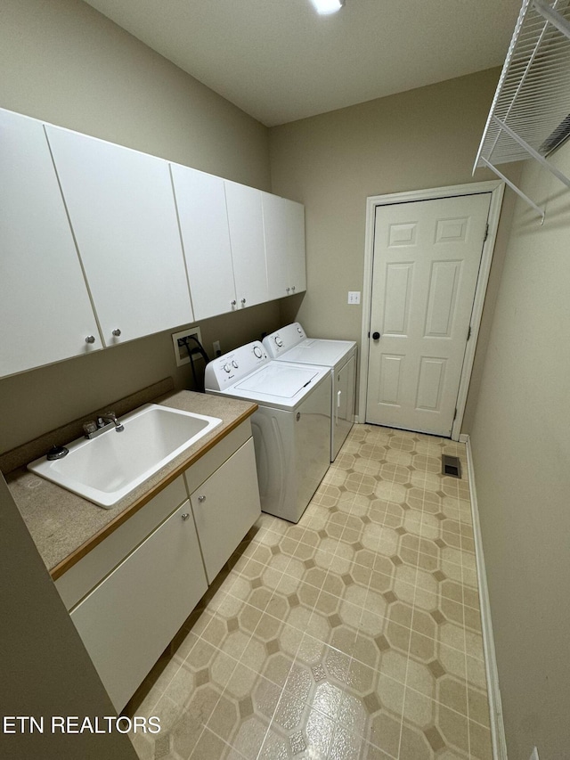 laundry room with independent washer and dryer, cabinets, and sink