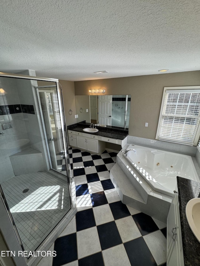 bathroom with vanity, a textured ceiling, and plus walk in shower