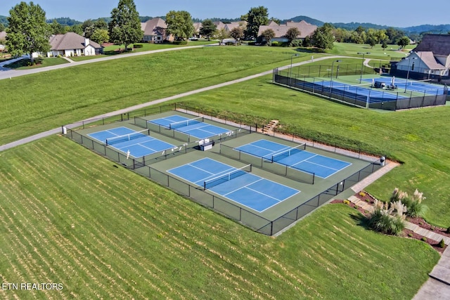 view of sport court with a yard and a mountain view