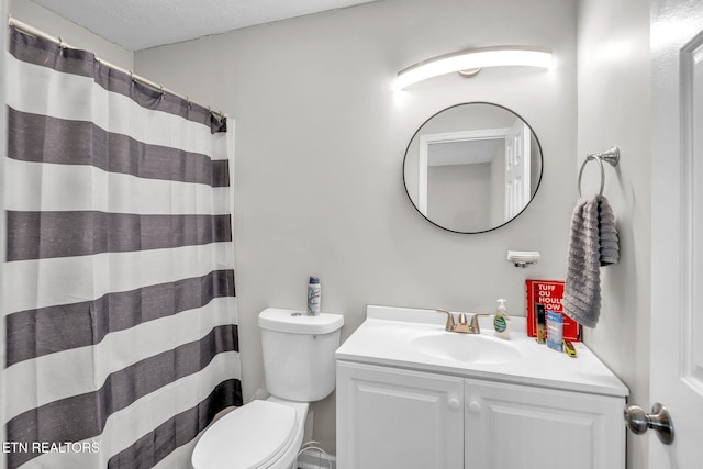 bathroom featuring vanity, walk in shower, a textured ceiling, and toilet