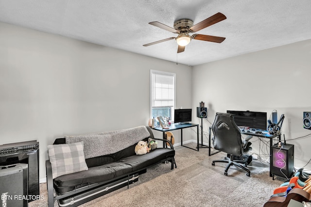 home office featuring light carpet, ceiling fan, and a textured ceiling