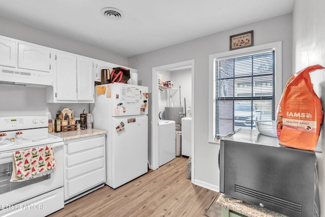 kitchen with white appliances, washing machine and dryer, white cabinets, and light wood-type flooring