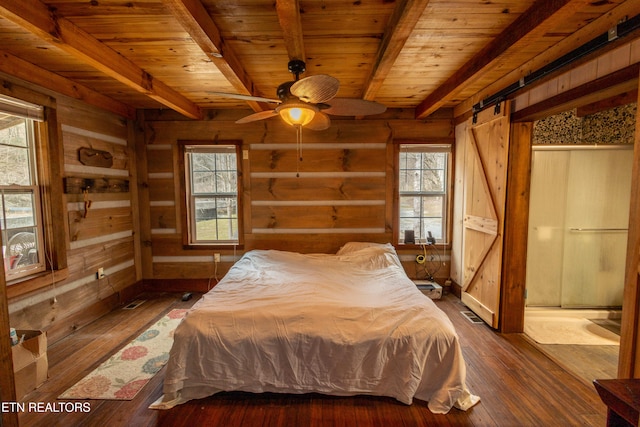 bedroom featuring wood ceiling, beam ceiling, dark hardwood / wood-style floors, a barn door, and wood walls