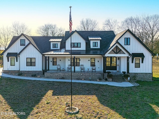 modern farmhouse style home with a yard and covered porch