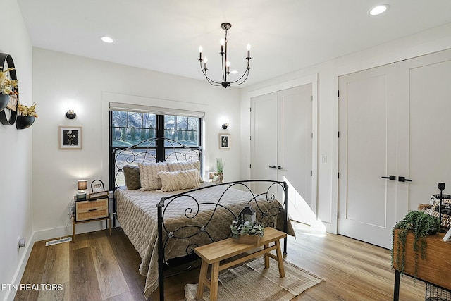 bedroom with an inviting chandelier and light hardwood / wood-style flooring