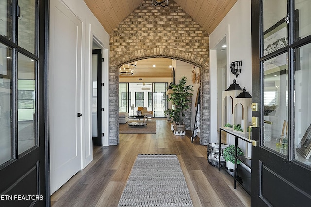 foyer entrance with dark hardwood / wood-style flooring, brick wall, and wood ceiling