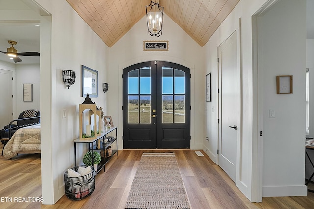 foyer featuring french doors, lofted ceiling, wood ceiling, an inviting chandelier, and hardwood / wood-style flooring