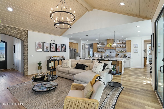 living room featuring wood ceiling, high vaulted ceiling, a chandelier, and light hardwood / wood-style floors