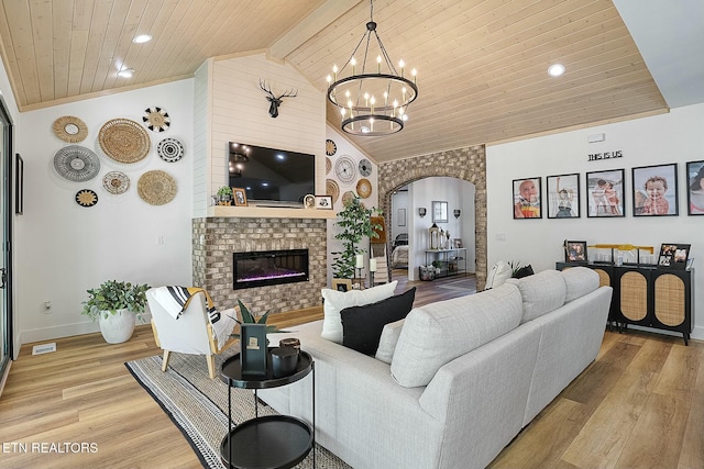 living room featuring lofted ceiling, light wood-type flooring, a fireplace, and wood ceiling