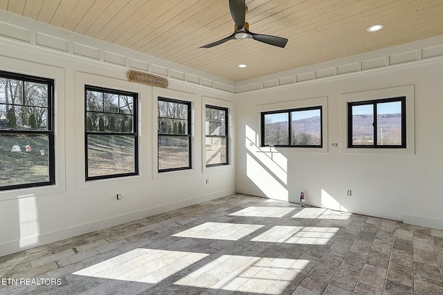 empty room featuring a wealth of natural light, wooden ceiling, and ceiling fan