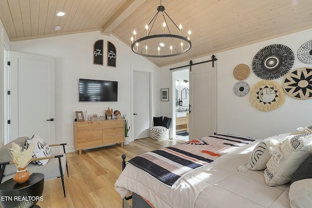 bedroom featuring connected bathroom, vaulted ceiling with beams, a barn door, wooden ceiling, and light wood-type flooring