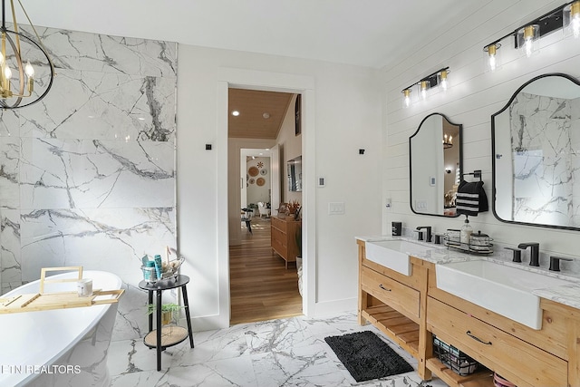 bathroom featuring a tub to relax in, vanity, and a notable chandelier